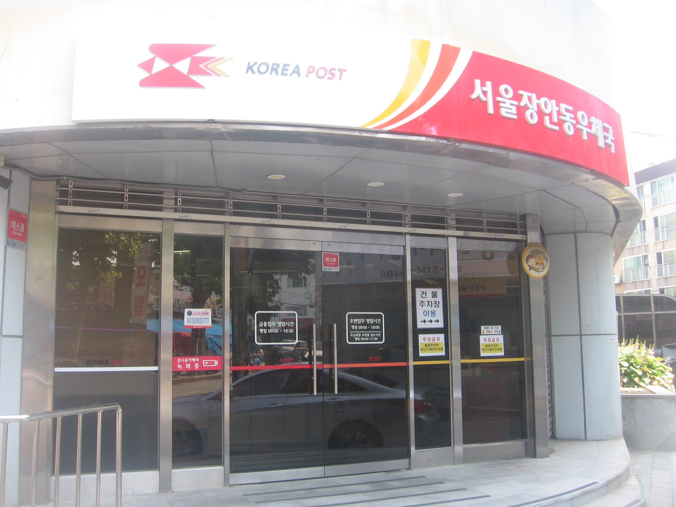 우체국 적금 가입 이벤트와 자동이체 조건을 설명하는 한국 우체국 건물