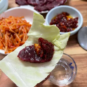 양배추에 뭉티기와 양념을 올린 모습